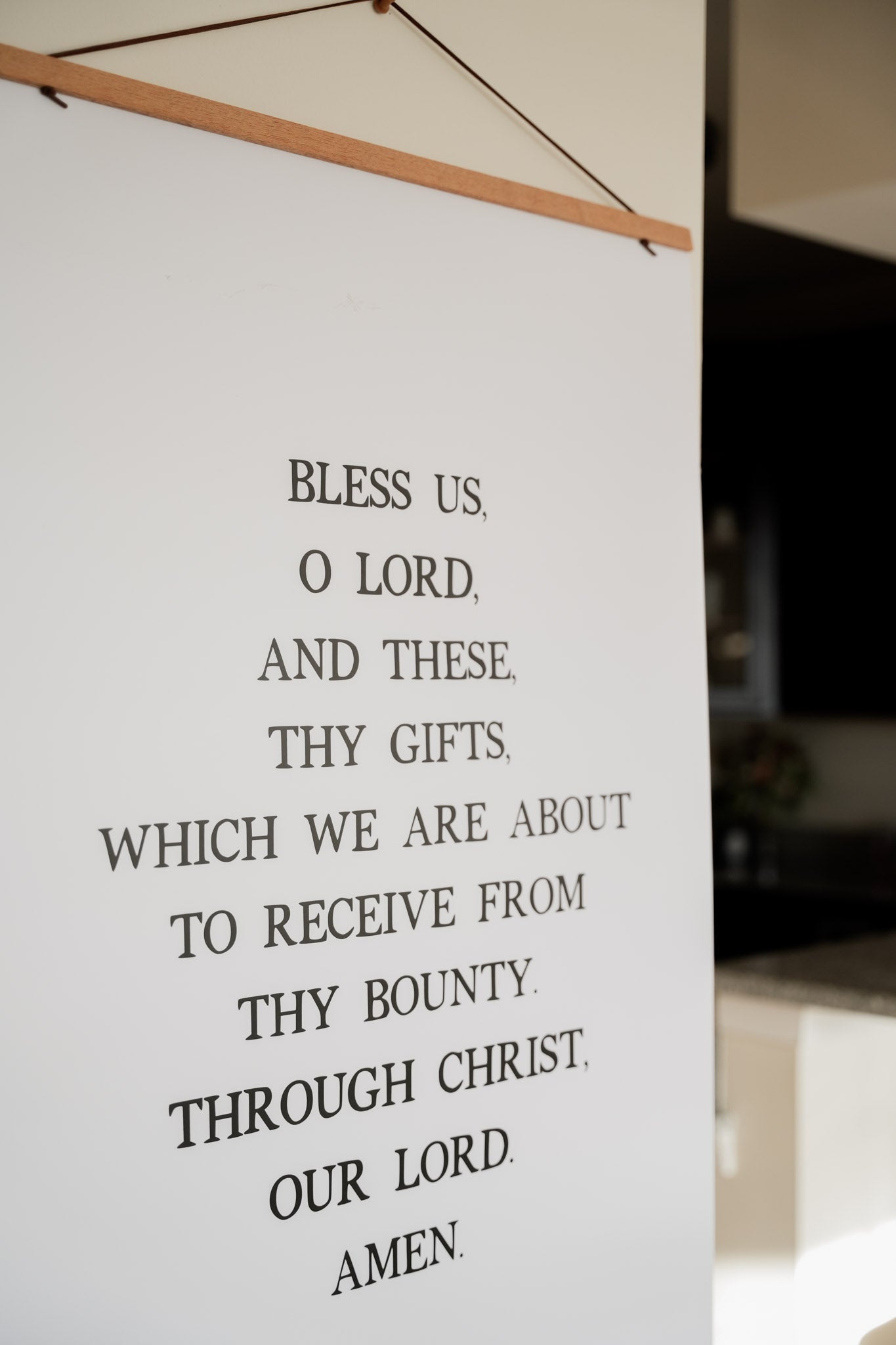Catholic prayer poster displaying the Grace Before Meals blessing, Bless us O Lord, in elegant black lettering on a clean white background