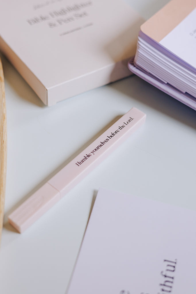 Pastel highlighters with Bible verse labels arranged in a row