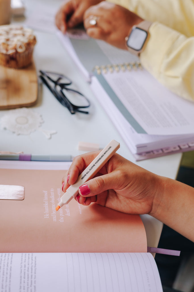 Flat lay of highlighters and pens on an open Bible page