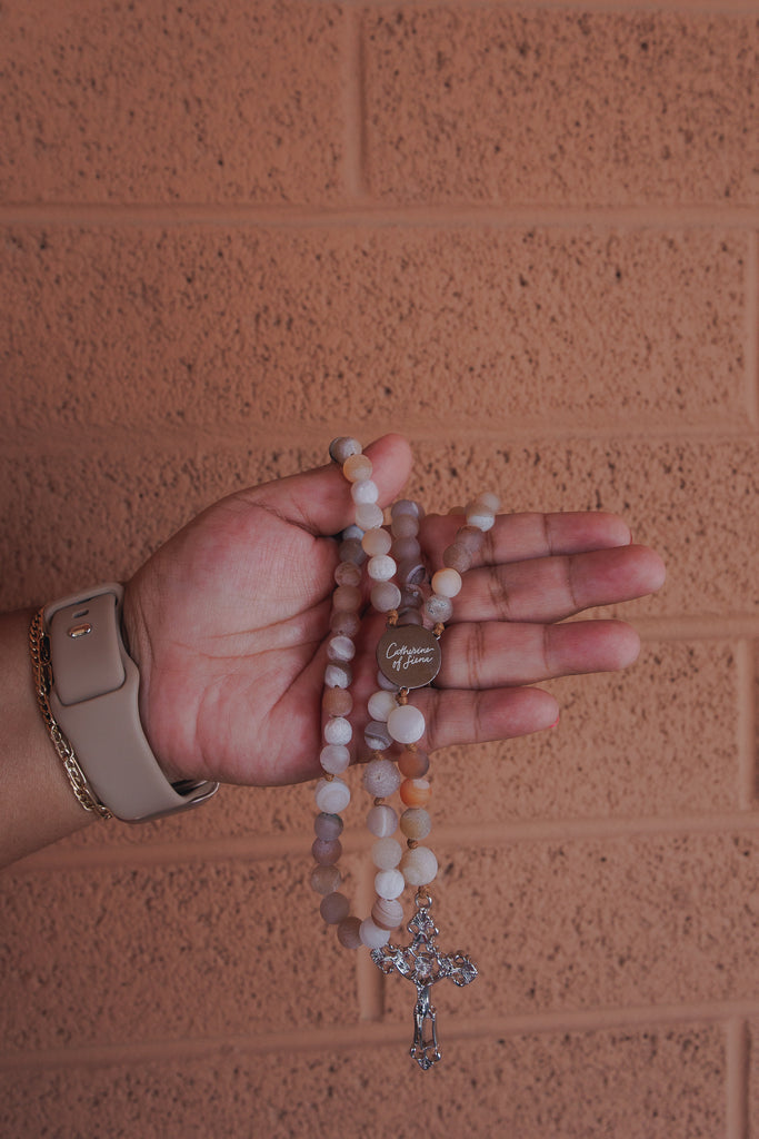 Hand praying with St Catherine of Siena Rosary