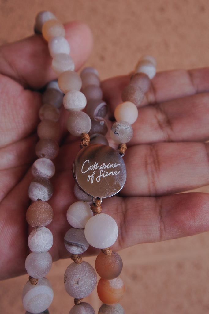 Hand praying with St Catherine of Siena Rosary