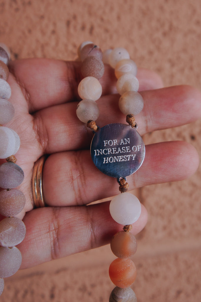 Hand praying with St Catherine of Siena Rosary