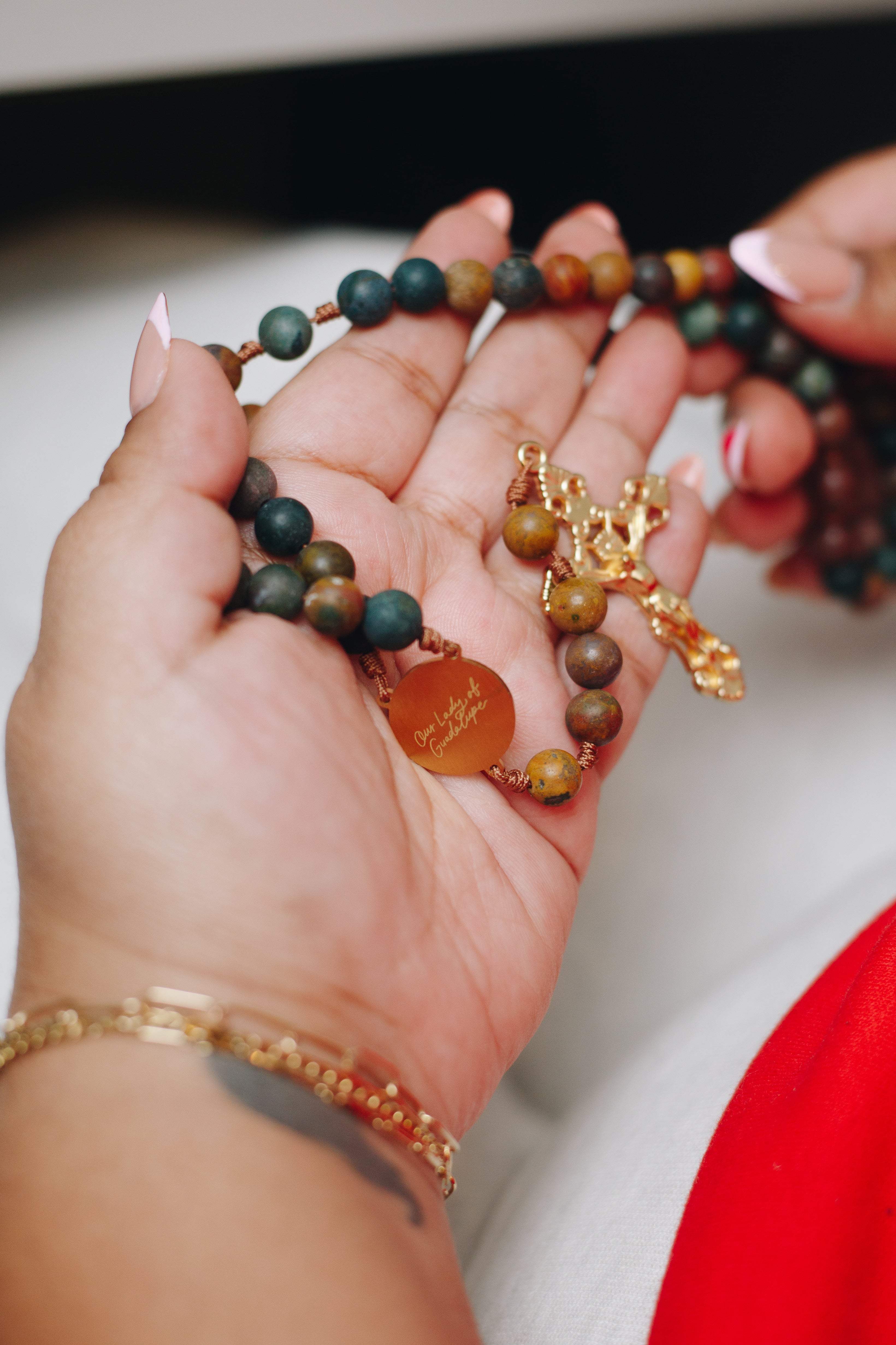 Hand praying with Our Lady of Guadalupe Rosary