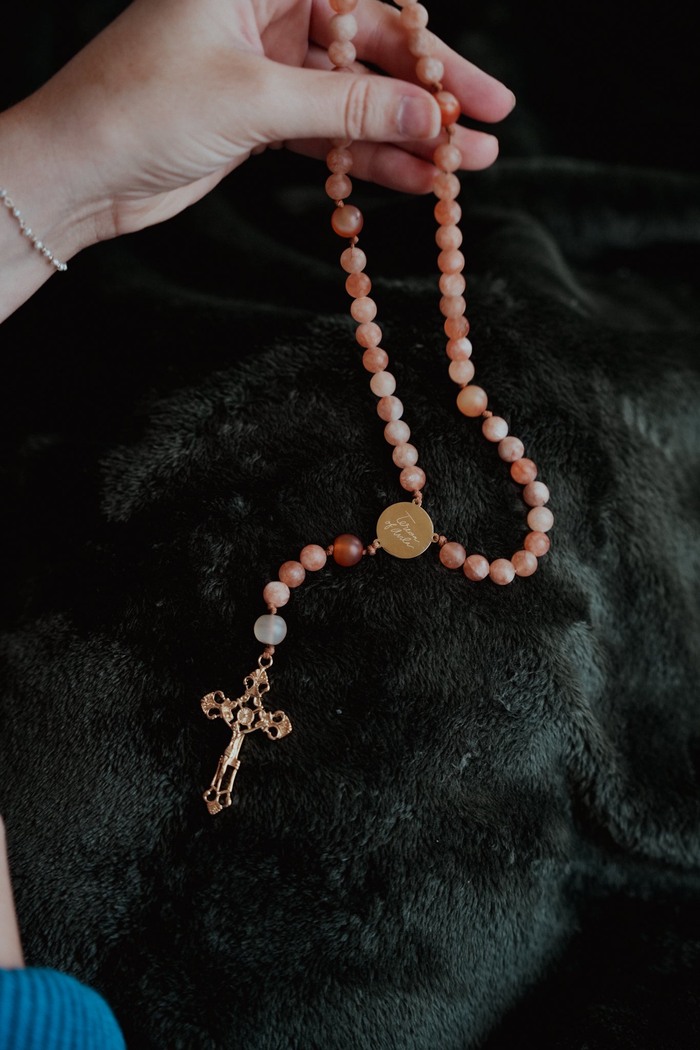 Hand holding St Teresa of Avila rosary