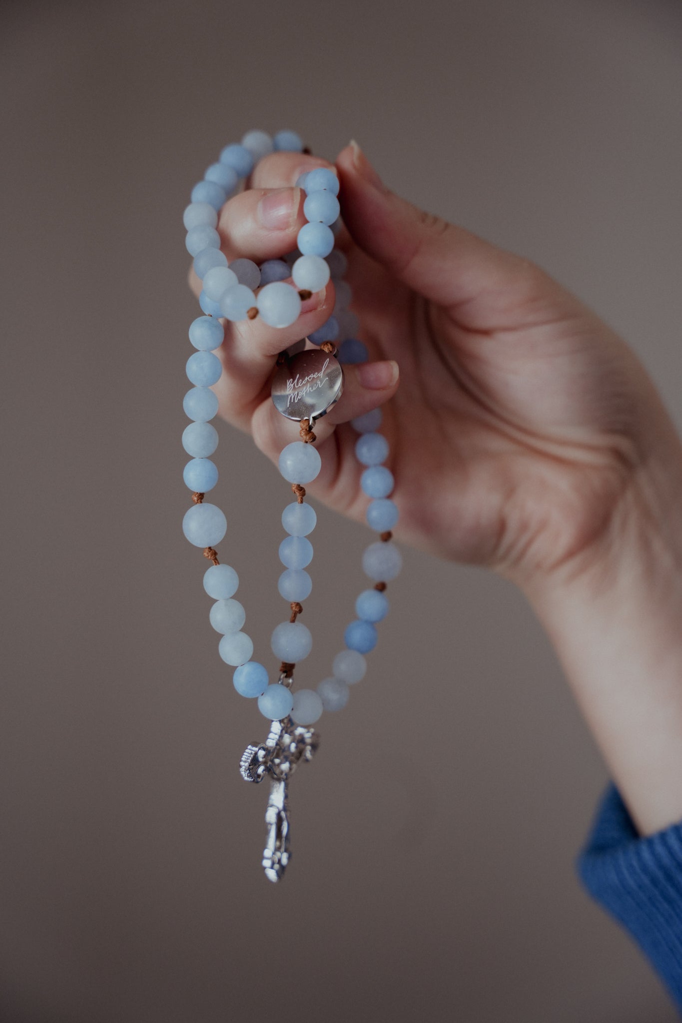 Hand holding the Blessed Mother Rosary