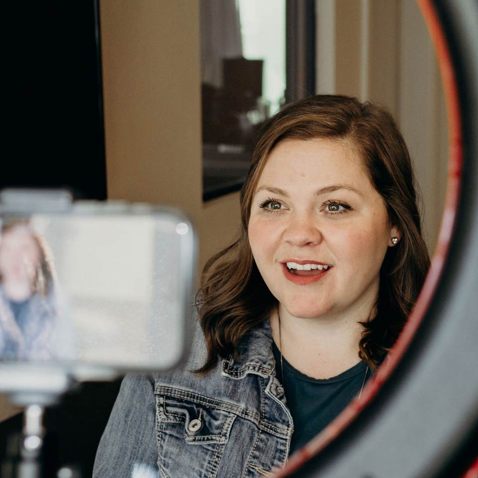 Woman filming Teachable Tuesday podcast with phone 