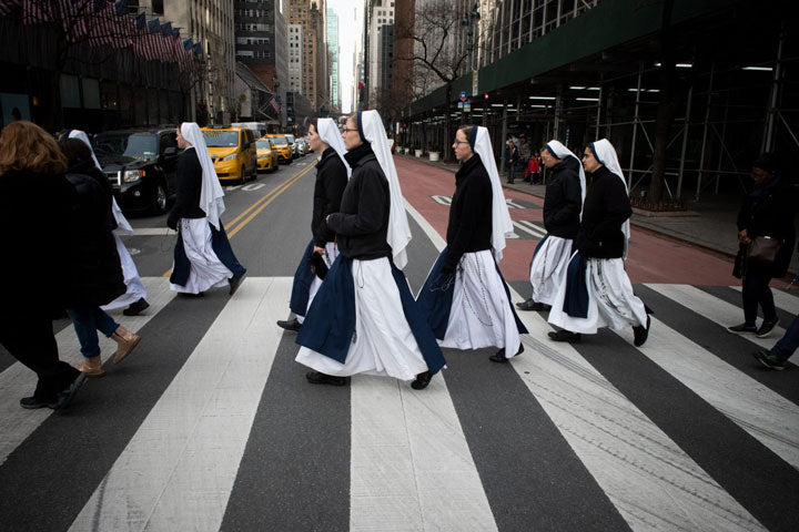 A group of nuns walking in a cross-walk