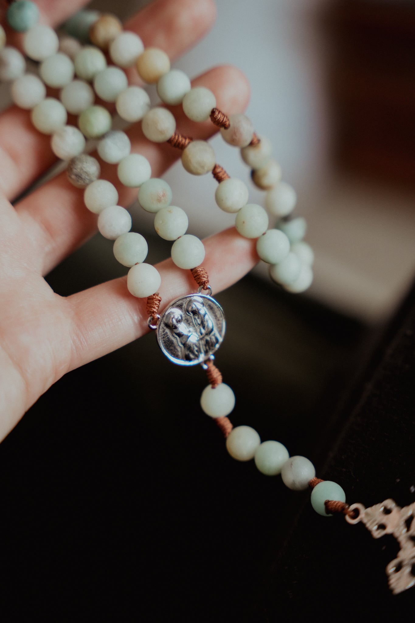 Hand holding a rosary while meditating on the Visitation mystery