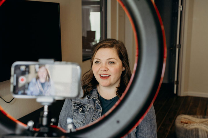 Woman recording a Teachable Tuesday video with her phone and ring light